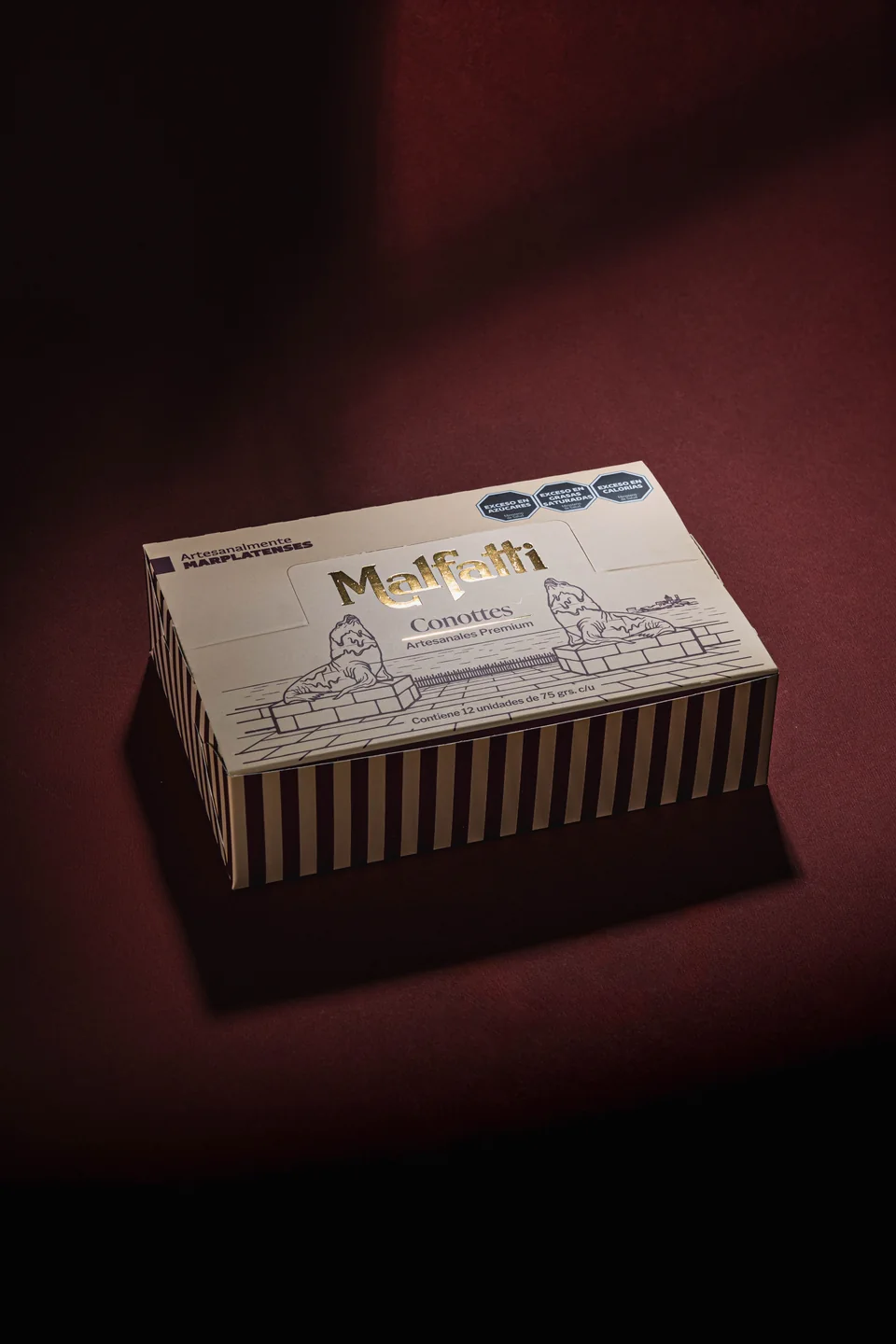 Caja Malfatti para Conottes vista en perspectiva, con la cara principal ilustrada y los laterales a rayas.